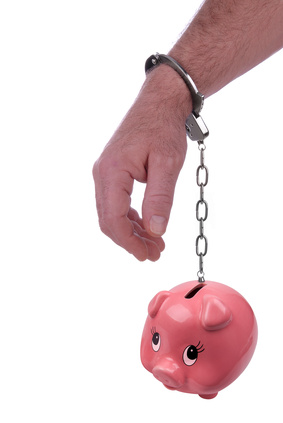 One hand handcuffed to a piggy bank